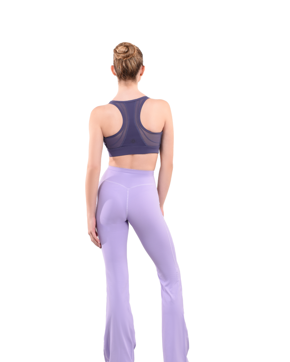 dancer in purple sports bra and lavender high rise flared stretch fit pants turned around