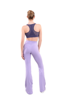 dancer in purple sports bra and lavender high rise flared stretch fit pants turned around