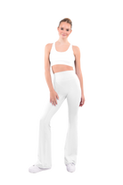 dancer in white sports bra and white high rise flared stretch fit pants