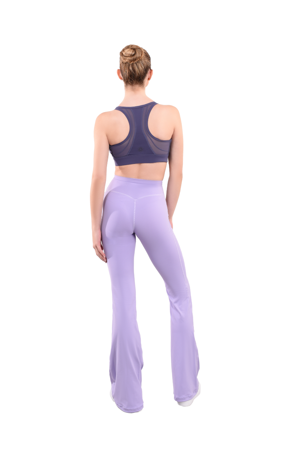 dancer in purple sports bra and lavender high rise flared stretch fit pants turned around